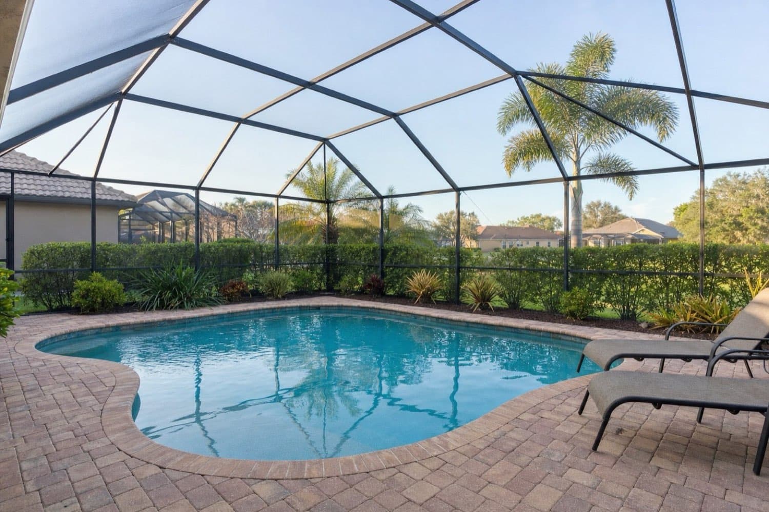 Beautiful screened swimming pool maintained by Surfrider Pool Service