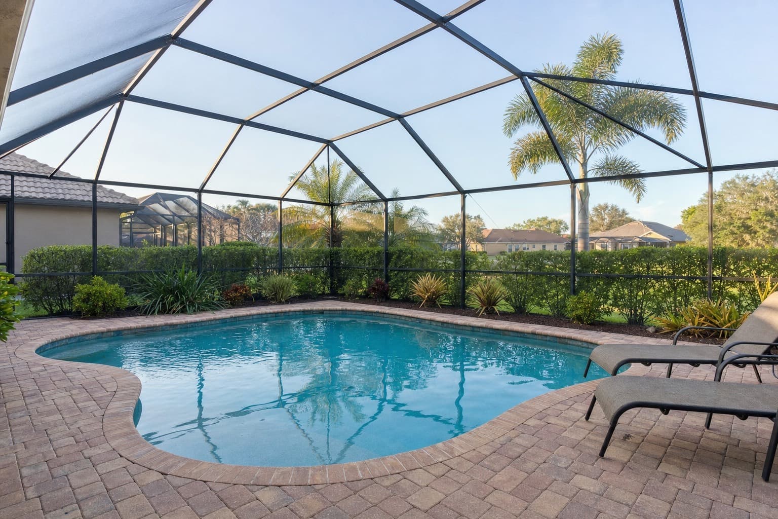 Beautiful screened swimming pool maintained by Surfrider Pool Service