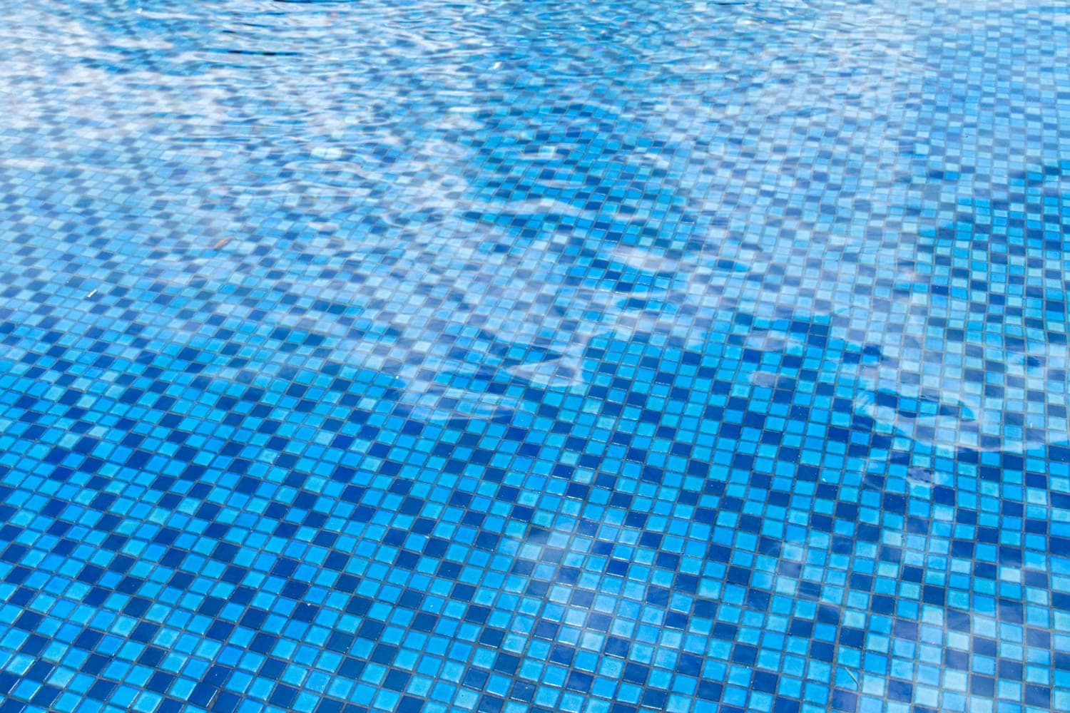 Close up of clean blue tiled swimming pool water